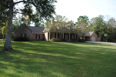 Inspiration for a large timeless red two-story brick house exterior remodel in Houston with a shingle roof