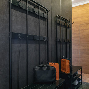 Idées déco pour une petite porte d'entrée éclectique avec un sol en carrelage de porcelaine, une porte simple, une porte marron et un sol noir.