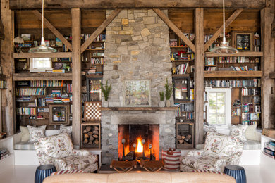Living room library - rustic open concept exposed beam living room library idea in Boston with a standard fireplace and a stone fireplace