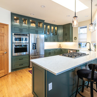 Esempio di un cucina con isola centrale chic con lavello stile country, ante verdi, paraspruzzi bianco, elettrodomestici in acciaio inossidabile, pavimento in legno massello medio, pavimento arancione e top bianco