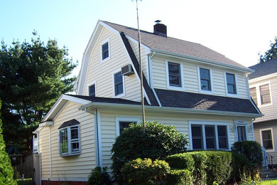 Mid-sized elegant yellow two-story vinyl gable roof photo in Huntington