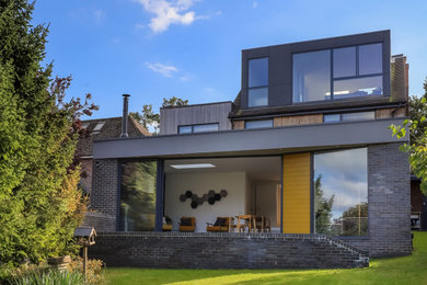 Photo of a medium sized contemporary rear house exterior in Hampshire with three floors and mixed cladding.
