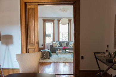 Example of a mid-sized transitional light wood floor dining room design in New York with white walls