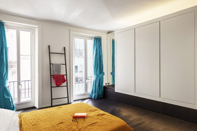 Exemple d'une grande chambre parentale tendance avec un mur blanc, parquet foncé et aucune cheminée.