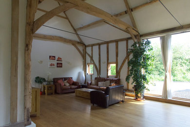 Mittelgroßes, Offenes Country Wohnzimmer mit weißer Wandfarbe, hellem Holzboden, freistehendem TV und braunem Boden in Buckinghamshire