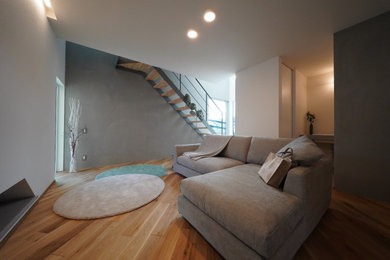 Идея дизайна: гостиная комната в стиле лофт с серыми стенами, паркетным полом среднего тона, коричневым полом и потолком с обоями