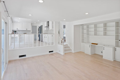 Example of a mid-sized minimalist open concept vinyl floor and beige floor living room library design in San Francisco with white walls, a standard fireplace, a stone fireplace and no tv