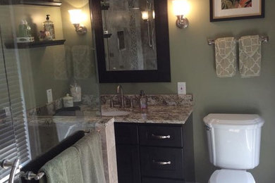 Corner shower - small 3/4 beige tile and ceramic tile ceramic tile corner shower idea in Tampa with an undermount sink, black cabinets, granite countertops, a two-piece toilet, green walls and flat-panel cabinets