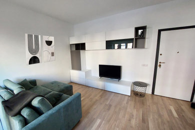 Esempio di un piccolo soggiorno scandinavo aperto con libreria, pareti bianche, parquet chiaro, TV a parete e pavimento beige