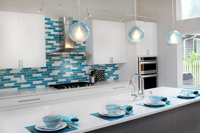 Eat-in kitchen - large contemporary l-shaped dark wood floor eat-in kitchen idea in Seattle with an undermount sink, flat-panel cabinets, white cabinets, quartz countertops, blue backsplash, glass tile backsplash, stainless steel appliances and an island