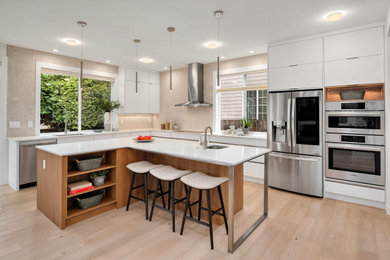 Open concept kitchen - mid-sized contemporary l-shaped light wood floor and beige floor open concept kitchen idea in Seattle with an undermount sink, flat-panel cabinets, white cabinets, quartz countertops, gray backsplash, porcelain backsplash, stainless steel appliances, an island and white countertops