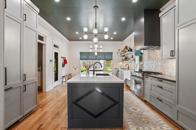 Example of a large transitional medium tone wood floor eat-in kitchen design in Atlanta with an undermount sink, shaker cabinets, gray cabinets, quartz countertops, white backsplash, porcelain backsplash, paneled appliances and an island