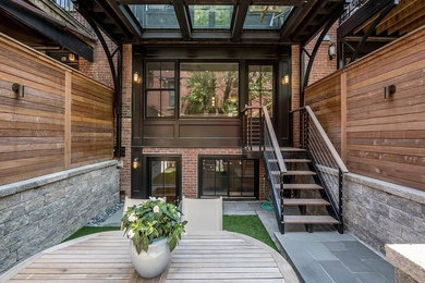 Mid-sized trendy brown three-story brick exterior home photo in Boston with a mixed material roof and a black roof