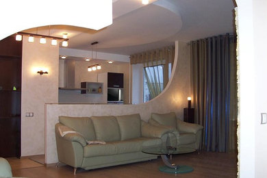Пример оригинального дизайна: парадная, открытая гостиная комната среднего размера в стиле модернизм с бежевыми стенами, темным паркетным полом, телевизором на стене и коричневым полом