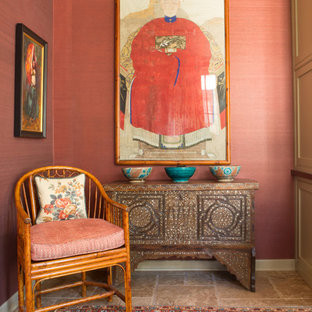 Mid-sized eclectic study room in Los Angeles with red walls, travertine floors, no fireplace and a built-in desk.