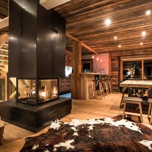 グルノーブルの広いラスティックスタイルのLDKの画像 (無垢フローリング、両方向型暖炉、金属の暖炉まわり)