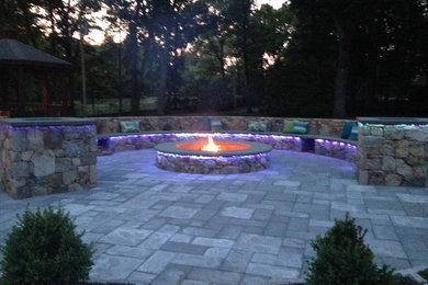 Example of a minimalist courtyard concrete paver patio design in Providence with a fire pit