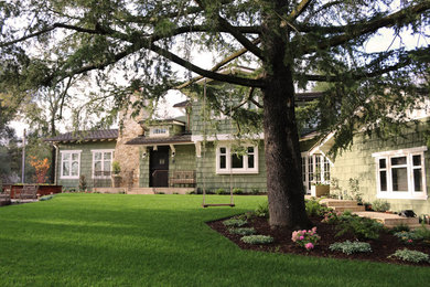 Example of a large mountain style green two-story wood exterior home design in San Francisco