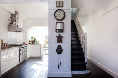 Medium sized contemporary hallway in London with white walls, dark hardwood flooring, a single front door and a medium wood front door.