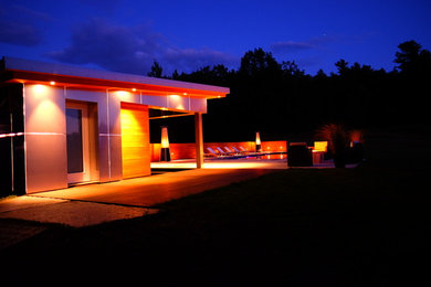 Réalisation d'une façade de maison métallique minimaliste de taille moyenne avec un toit en appentis et un toit en métal.