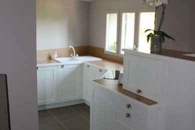 Aménagement d'une cuisine ouverte moderne avec un plan de travail en bois, une crédence en bois, un sol en carrelage de céramique et un sol gris.