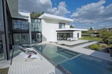 Photo of a mid-sized contemporary front yard rectangular lap pool in Lyon.