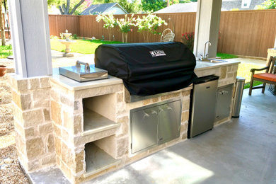 Backyard concrete patio kitchen photo in Dallas with a gazebo