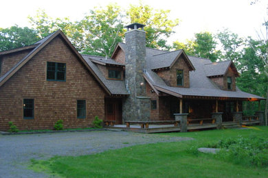 Large mountain style brown two-story wood exterior home photo in Other with a shingle roof