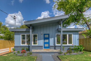 Example of a mid-sized minimalist blue one-story concrete fiberboard house exterior design in Austin with a shed roof and a shingle roof