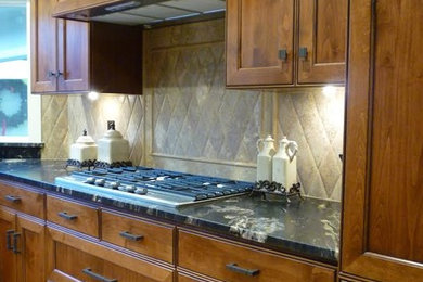 Example of a small transitional u-shaped medium tone wood floor eat-in kitchen design in Other with recessed-panel cabinets, medium tone wood cabinets, granite countertops, stone tile backsplash and a peninsula