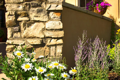 Photo of a mid-sized traditional partial sun front yard mulch formal garden in Denver for spring.