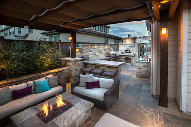 Patio kitchen - large mediterranean backyard stone patio kitchen idea in San Francisco with a pergola