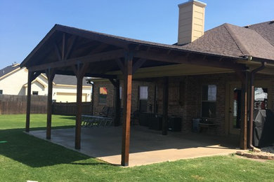 Example of a mid-sized classic backyard concrete paver patio design in Austin with a pergola