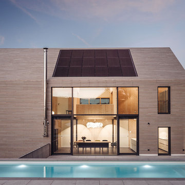 Südfassade mit großer Öffnung PV-Anlage im Dach und vorgelagertem Pool