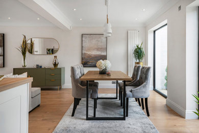 Photo of a medium sized open plan dining room in London with light hardwood flooring and white floors.