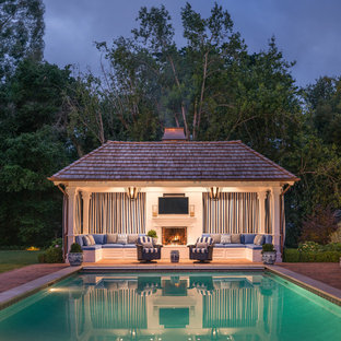 Idéer för att renovera en stor vintage rektangulär pool på baksidan av huset, med poolhus och marksten i tegel