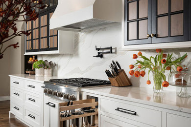 Inspiration for a mid-sized transitional galley open plan kitchen in Other with an undermount sink, quartz benchtops, white splashback, engineered quartz splashback, stainless steel appliances, medium hardwood floors, with island, brown floor and white benchtop.