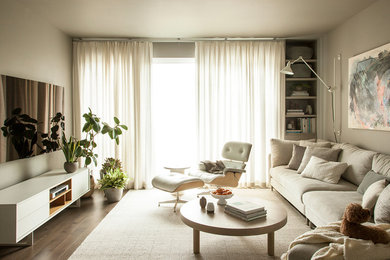 Example of a mid-sized minimalist open concept medium tone wood floor and gray floor living room design in Seattle with gray walls and a wall-mounted tv
