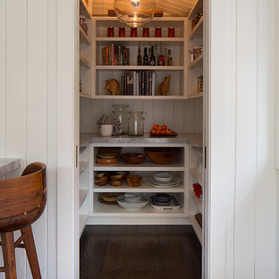 Idées déco pour une grande arrière-cuisine contemporaine en U avec des portes de placard blanches, un plan de travail en marbre, un électroménager en acier inoxydable, un îlot central et un sol en bois foncé.