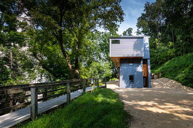 Small minimalist gray three-story metal house exterior photo with a metal roof