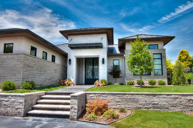 This is an example of a contemporary one-storey grey exterior in Dallas with stone veneer.