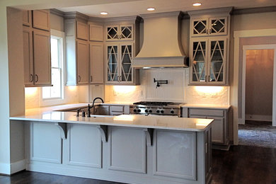 Inspiration for a large transitional u-shaped dark wood floor and brown floor open concept kitchen remodel in Atlanta with a farmhouse sink, glass-front cabinets, white backsplash, mosaic tile backsplash, beige cabinets, quartzite countertops, paneled appliances and a peninsula