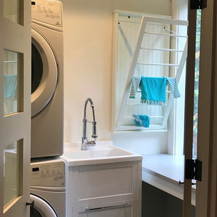シアトルの小さいおしゃれな家事室 (スロップシンク、シェーカースタイル扉のキャビネット、白いキャビネット、クオーツストーンカウンター、白い壁、スレートの床、上下配置の洗濯機・乾燥機、緑の床、グレーのキッチンカウンター) の写真