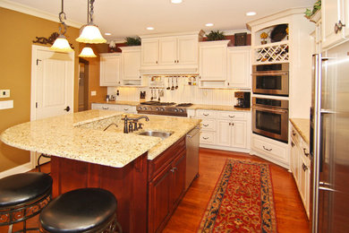 Eat-in kitchen - mid-sized traditional l-shaped medium tone wood floor eat-in kitchen idea in Indianapolis with a double-bowl sink, raised-panel cabinets, medium tone wood cabinets, granite countertops, white backsplash, stainless steel appliances and an island