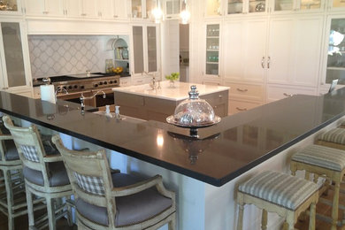 Example of a trendy light wood floor kitchen design in Phoenix with a farmhouse sink, white cabinets, quartz countertops, multicolored backsplash, mosaic tile backsplash, stainless steel appliances, an island and beaded inset cabinets