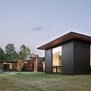 Example of a minimalist black one-story wood house exterior design in Charlotte with a shed roof