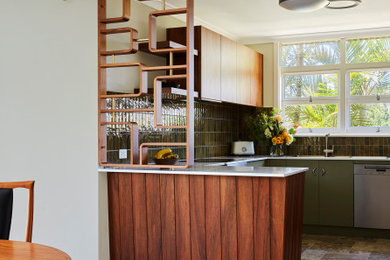 Mid-sized midcentury u-shaped open plan kitchen in Sydney with a double-bowl sink, flat-panel cabinets, medium wood cabinets, quartz benchtops, green splashback, ceramic splashback, stainless steel appliances, travertine floors, a peninsula, beige floor and white benchtop.