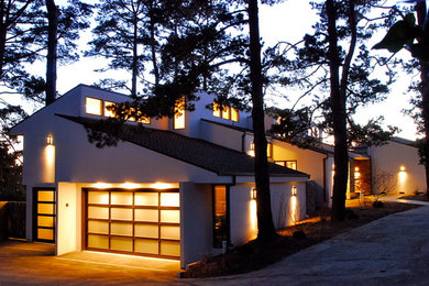 Large trendy white two-story stucco house exterior photo in San Francisco with a shed roof and a shingle roof