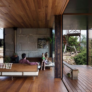 Modern inredning av ett vardagsrum, med mellanmörkt trägolv och en öppen vedspis