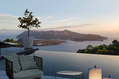 Immagine di una piscina a sfioro infinito mediterranea rettangolare di medie dimensioni e dietro casa con paesaggistica bordo piscina e lastre di cemento